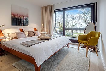 Ein modernes Schlafzimmer mit bodentiefem Fenster